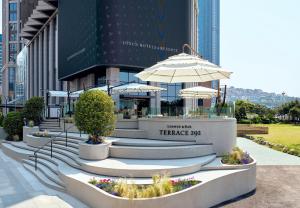 a table with an umbrella in front of a building at Grand Josun Busan in Busan