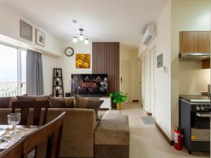 ein Wohnzimmer mit einer Couch und einem Tisch darin in der Unterkunft Family-Ready Skyline Retreat near BGC with Free Parking in Manila