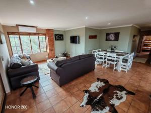een woonkamer met een bank en een tafel bij Lion's Pride - Marloth Park in Marloth Park