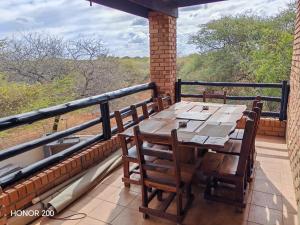 een tafel en stoelen op een balkon met uitzicht bij Lion's Pride - Marloth Park in Marloth Park