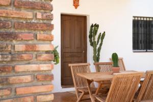 a dining room with a table and chairs and a brick wall at Los jardines de Zahora C02 in Cádiz