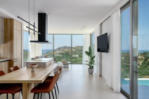 una cucina e una sala da pranzo con tavolo e sedie di New Villa Plakias Sunset II with Infinity Pool in South Crete a Dhamnóni