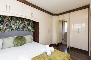 a bedroom with a large white bed and a wall of cabinets at Hazel House Spacious 3BR Home Parking WiFi Contractor Friendly in Ifield