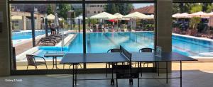 a table with a laptop on it next to a swimming pool at Holiday Beach Budapest Wellness Hotel with Sauna Park in Budapest