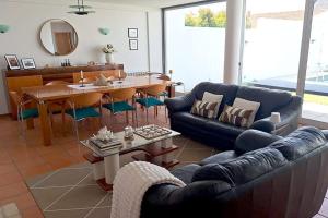 a living room with a couch and a dining room at Pena's Family Beach House in Arcozelo