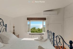 een witte slaapkamer met een bed en een raam bij Infinito, Terre Marine in Levanto