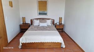 a bedroom with a bed with two night stands and two tables at Pena's Family Beach House in Arcozelo +32 photos