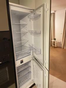an empty refrigerator with its door open in a room at Emerald Home in Suceava