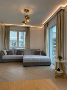 a living room with a couch and some windows at Emerald Home in Suceava