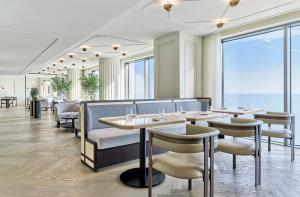 a restaurant with tables and chairs and a view of the ocean at Grand Josun Busan in Busan