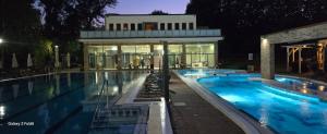 a large swimming pool with a building in the background at Holiday Beach Budapest Wellness Hotel with Sauna Park in Budapest