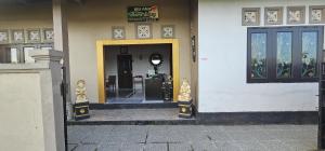 a entrance to a building with a sign on the wall at Ibu Ana Homestay in Tabanan