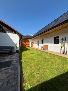 a backyard of a house with a green lawn at Chalupa Tri Sýpky in Blatnica
