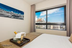 sypialnia z łóżkiem i dużym oknem w obiekcie Passos Manuel by Innapartments w Porto