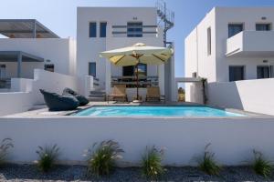 a swimming pool with an umbrella and an umbrella at Villa Evi in Kastraki