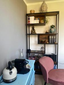 a kitchen with a table and a pink chair at B&B Bakenberg in Arnhem