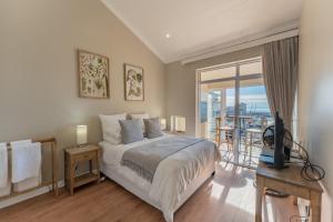 a bedroom with a large bed and a balcony at 9 Quarter Deck in St Francis Bay