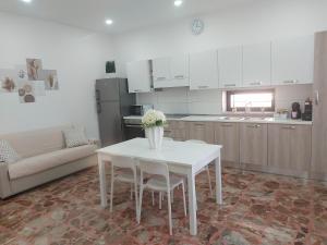 a kitchen with a white table and chairs in a kitchen at Modestina's house in Mondragone