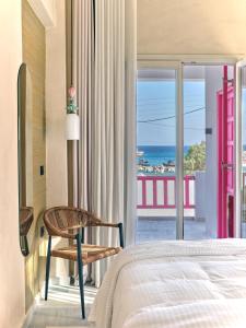 a bedroom with a bed and a view of the ocean at Anchorage Paros Boutique & Private Beach in Piso Livadi
