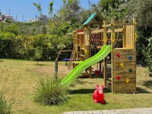a playground with a toy pig next to a slide at Made of Blue luxury suites collection in Rethymno