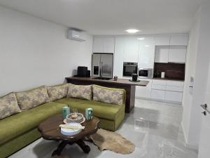a living room with a green couch and a table at Villa Farah in Semizovac