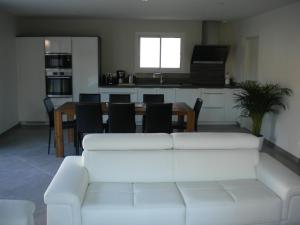 uma sala de estar com um sofá branco e uma mesa em Nokanhui em Soulac-sur-Mer