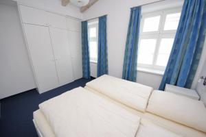 Una sala de estar con un sofá blanco y una ventana. en Vorderreihe, Fewo 108, en Travemünde