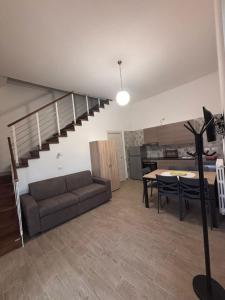 a living room with a couch and a staircase at Casa Helvius - Dimora in centro storico in Sant'Egidio del Monte Albino