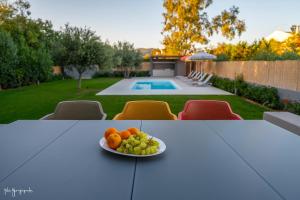 a plate of fruit on a table in a backyard at Apartment inside Villa Daniela-Elegant & Luxury Style-Private Pool in Schinias