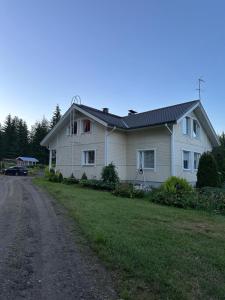 una casa bianca con una strada davanti di Villa Paalasmaa a Paalasmaa