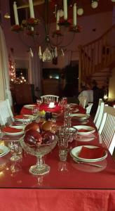 un lungo tavolo rosso con piatti e bicchieri di Villa Paalasmaa a Paalasmaa