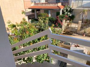 a white fence in front of a house with flowers at Almarea open space di Sulemmari in Scoglitti +22 photos