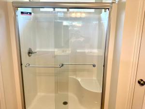 puerta de ducha de cristal con lavabo en el baño en Beautiful Spacious Family-Friendly Home, en Winston-Salem