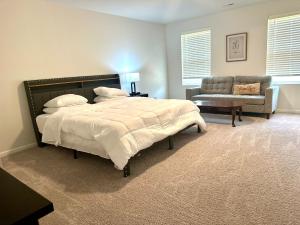 Un dormitorio con una cama, un sofá y una silla. en Beautiful Spacious Family-Friendly Home, en Winston-Salem
