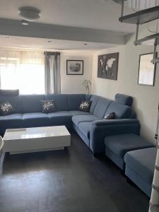 a living room with a blue couch and a coffee table at Tukhin's Residency - Studio Apartment & Deluxe 4 room Apartment in Korntal-Münchingen +58 photos