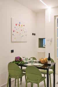 a dining room with a table and green chairs at Nice Stresa - Appartamento Isola Bella in Stresa
