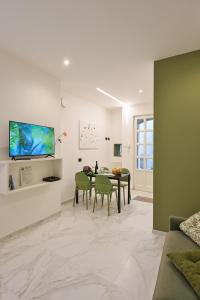 a living room with a table and green chairs at Nice Stresa - Appartamento Isola Bella in Stresa