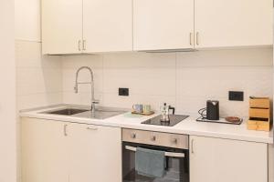 a kitchen with white cabinets and a sink at Nice Stresa - Appartamento Isola Bella in Stresa