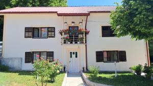 a white house with a window with a flower box at Domaćinstvo Koprivica in Zapolje