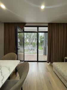 a living room with a table and chairs and sliding glass doors at Shaika resort Bibllan apartmens in Chon-Sary-Oy