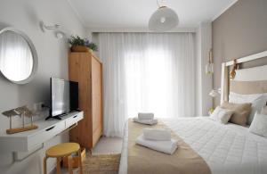 biała sypialnia z dużym łóżkiem i telewizorem w obiekcie Evangelia Rooms & Αpartments - B w mieście Asprovalta +37 zdjęć