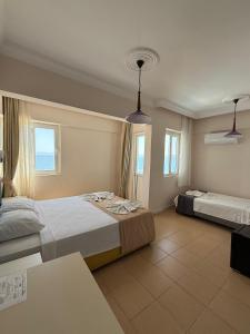 a hotel room with two beds and two windows at Er-Öz Hotel in Fethiye