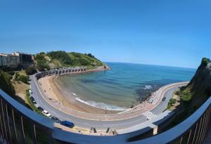a road next to a beach and the ocean at Apartamento con Encanto y Vistas al Mar en Getaria in Getaria