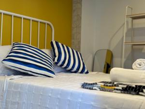 a bed with two blue and white pillows on it at Casa Faixa - Refugio en las Rías Baixas in Cangas de Morrazo