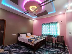 a bedroom with a bed and a ceiling with lights at HAMPI STAy in Hampi