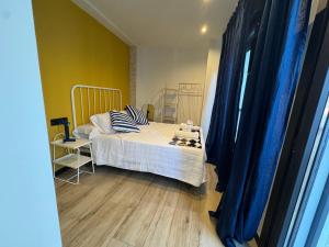 a bedroom with a bed with blue curtains and a window at Casa Faixa - Refugio en las Rías Baixas in Cangas de Morrazo