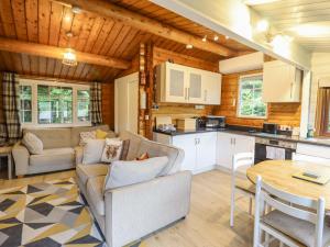 a living room with a couch and a table at Swn Yr Afon - No 333 in Trawsfynydd