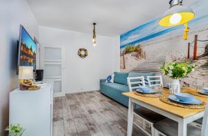 Una sala de estar con un sofá azul y una mesa. en Apartament Lokum, en Władysławowo