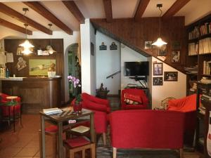een woonkamer met rode stoelen en een tafel bij Albergo Belvedere in Sequals
