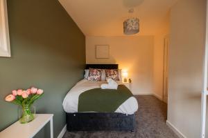 a bedroom with a bed and a vase of flowers at Einstein House By Horizon Stays in Stockton-on-Tees